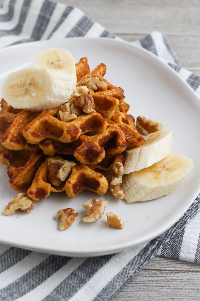 photo of waffles on plate topped with banana slices and walnuts | waffles are made with sweet potatoes and Manitoba Milling Smooth Whole Milled Flaxseed
