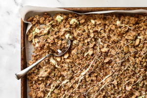 granola on a sheet pan with a spoon