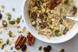 photo of flaxseed muesli in a bowl | contains oats, pepitas, raisins, and pecans, made with Manitoba Milling Smooth Whole Milled Flaxseed