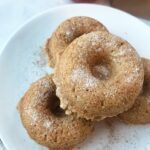 Four apple cider donuts on a plate