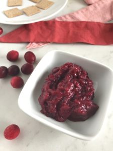 holiday side dish small square white bowl with scoop of red cranberry sauce