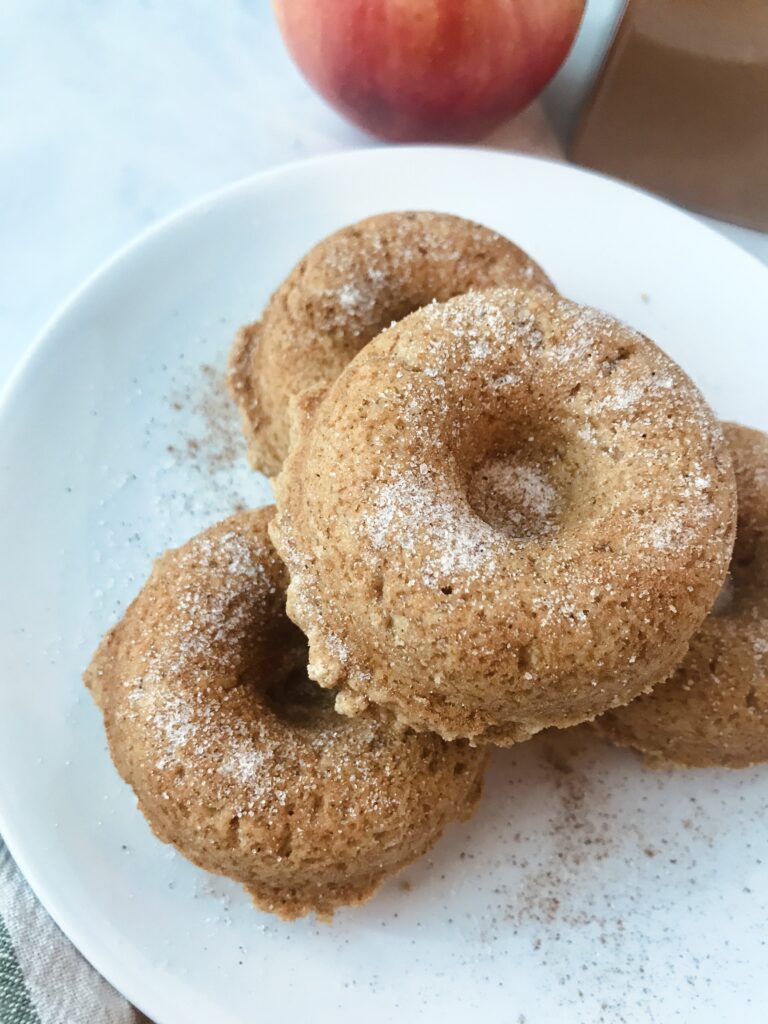 Four apple cider donuts on a plate