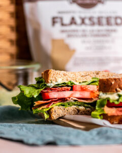 Sandwich sliced in half to reveal bacon, lettuce, and tomato on inside